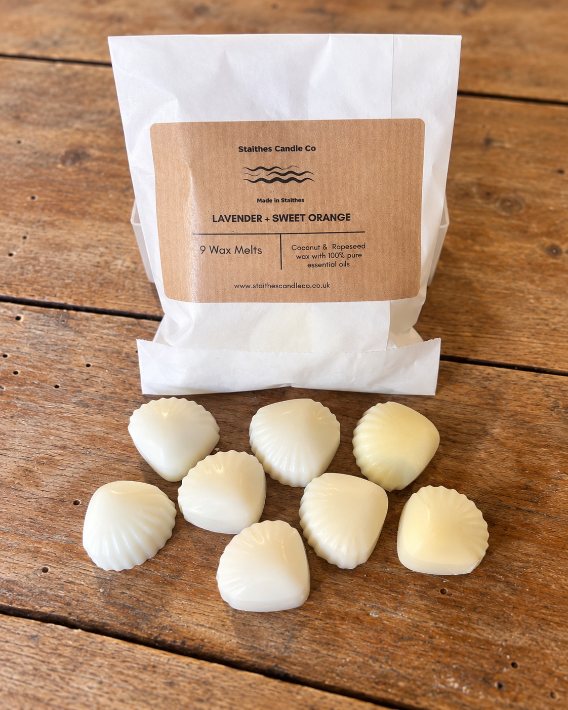 A white paper bag labeled 'Staithes Candle Co' with a brown kraft label reading 'Lavender + Sweet-Orange