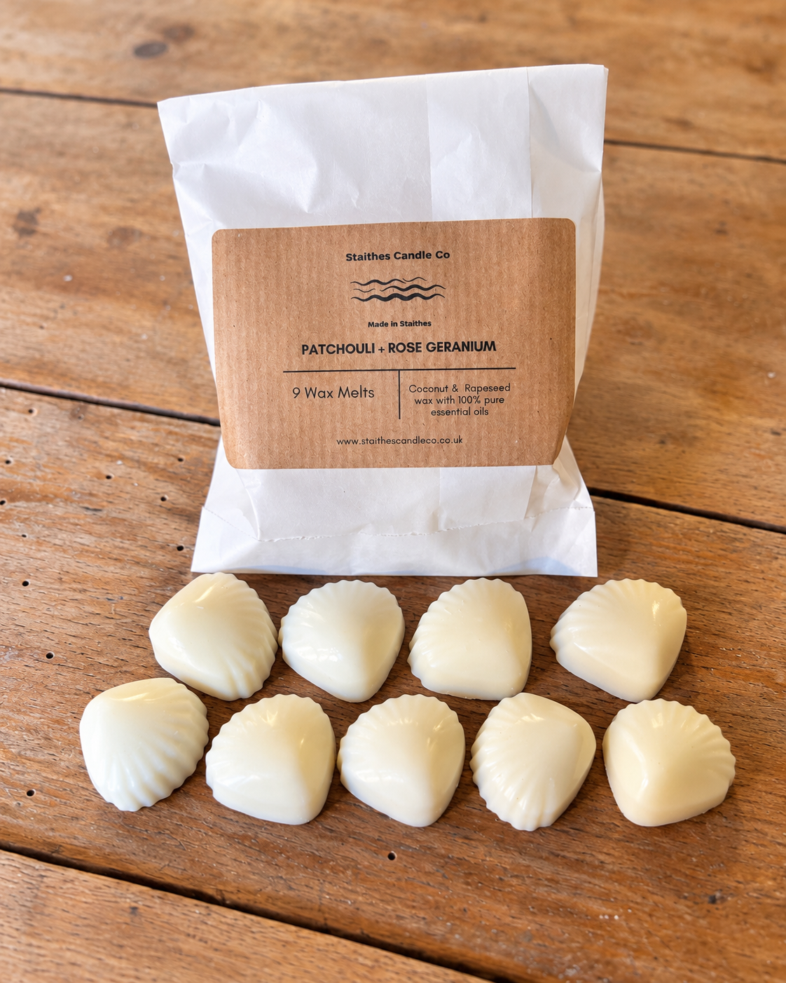 A white paper bag labeled Staithes Candle Co. PATCHOLLI - ROSE GERANIUM' with nine small white wax melts