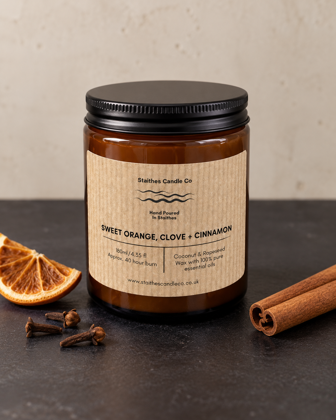 Sweet Orange, Clove & Cinnamon essential oil candle by Staithes Candle Co, pictured with orange, cloves and cinnamon sticks